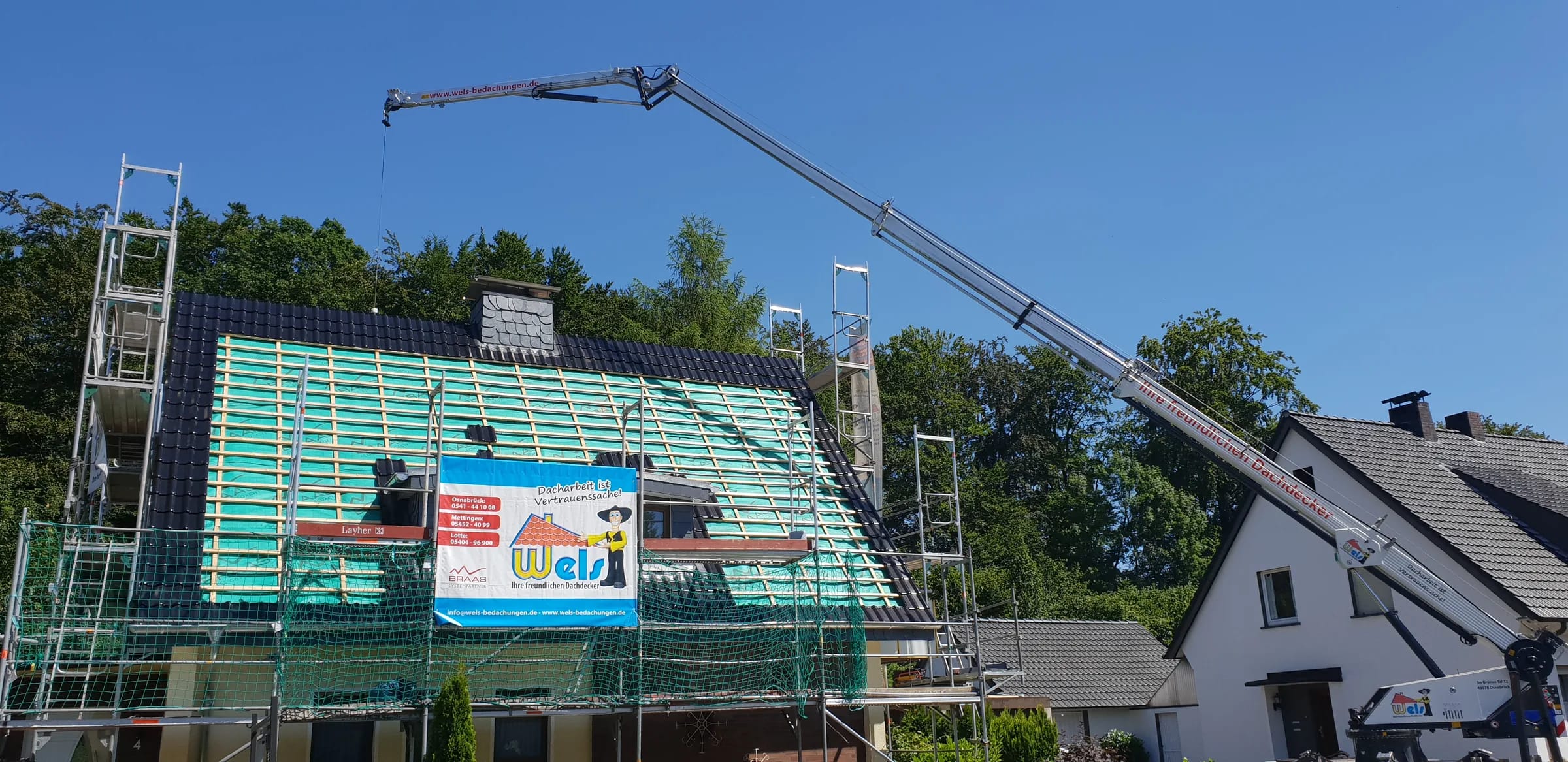 Baustelle von Wels Bedachungen mit Kran, Gerüst und neu gelattetem Steildach