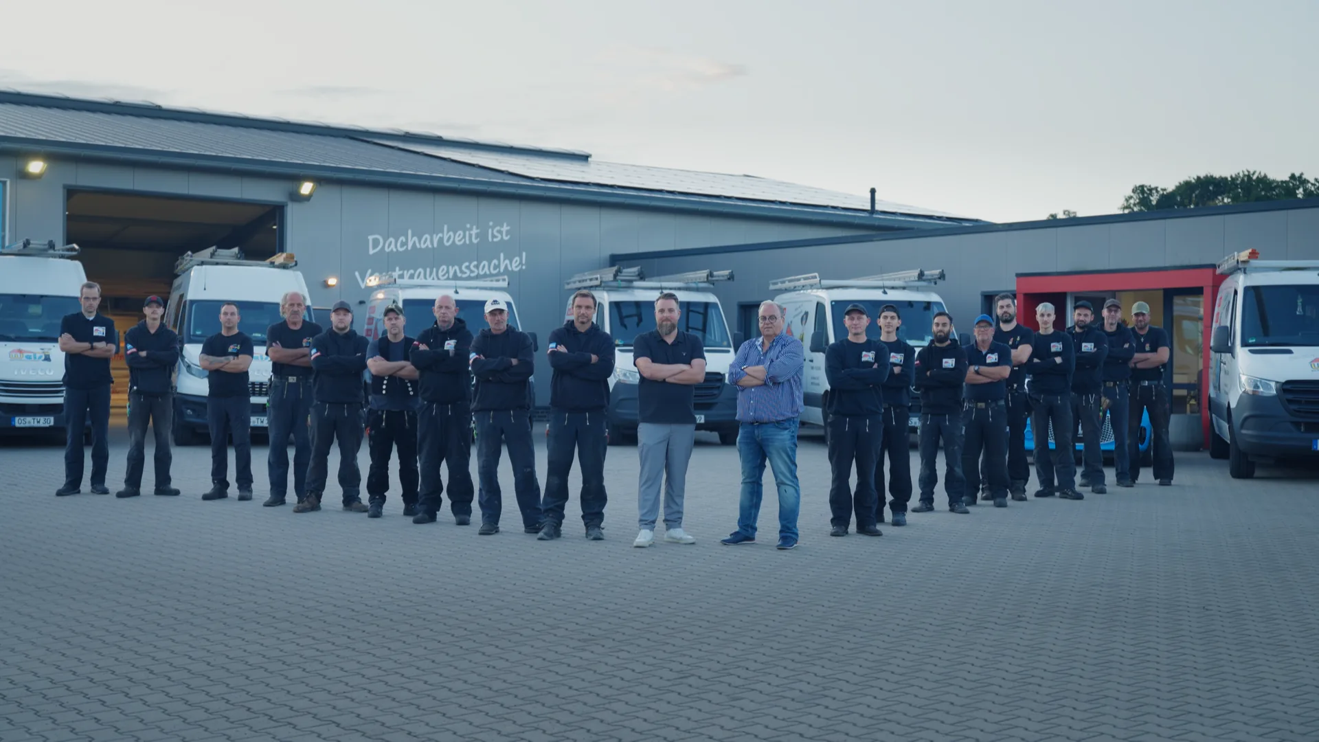 Das gesamte Wels-Team vor Firmenhalle und Fuhrpark in Lotte
