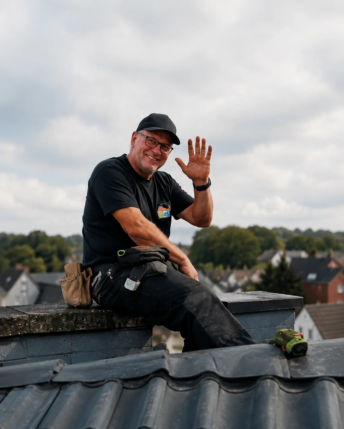 Wels-Dachdecker sitzt auf dem Dachfirst und winkt